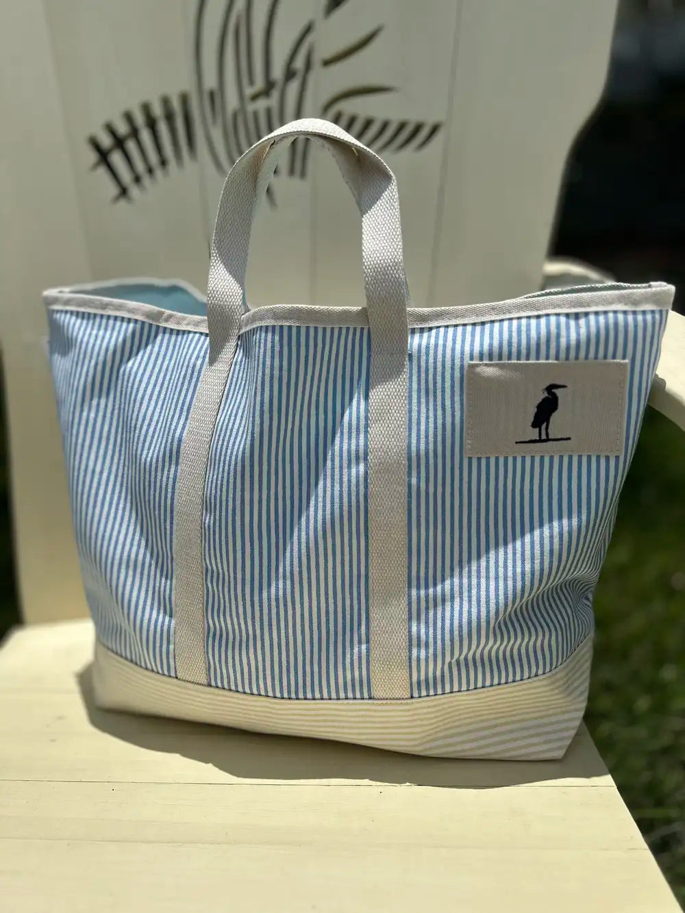 Tote Bag with heron icon stitched on the front.  The bag is pinstriped with a pretty blue on white.  The bag is made of canvas with sturdy straps. Eastern Shore Style. Boat tote bag, Beach tote bag, everyday bag. 