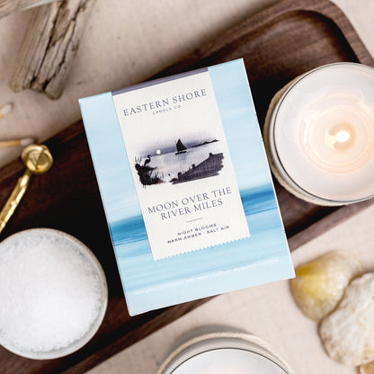 Moon over the River Miles candle illustration, Sailboat on the River Miles outside of St. Michaels in MD.  Eastern Shore Co. Candle box with candle on wooden tray. Hand poured in very small batches on the eastern shore. saint michaels, st. michaels, moon, moonlight, moonlit, amber scent, jasmine scent, night blooms scent, summer candle, sultry candle, Scented candle, coconut soy wax, coastal candle, eastern shore, Chesapeake Bay, luxury candle, Maryland, Virginia, 